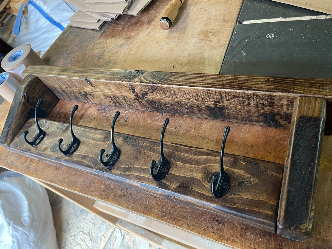 Five-hook Dark Oak waxed wooden coat rack shelf, angled view showing the wood grain and black hooks