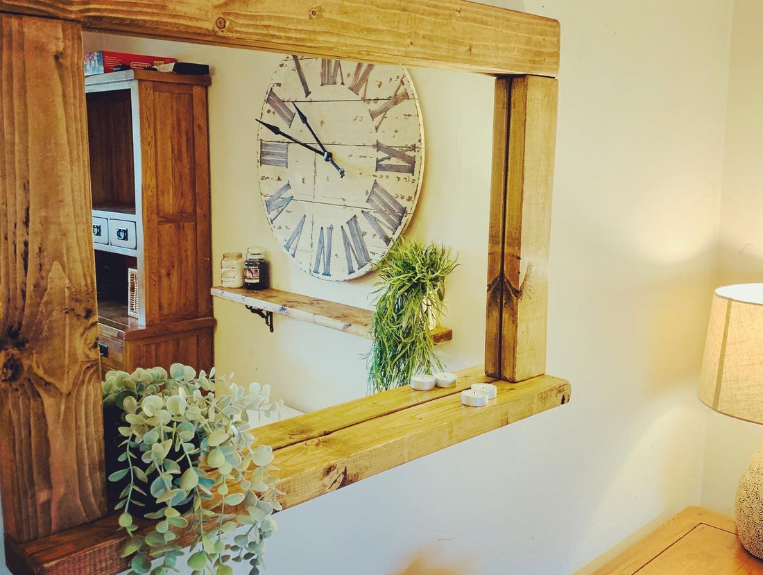 Rustic wooden shelf mirror reflecting a wall clock, with a trailing plant and tealights